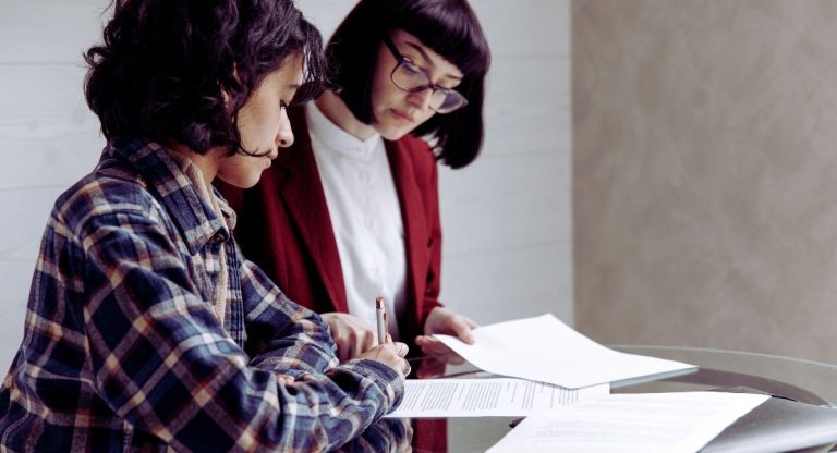 Femme signant un document juridique avec un conseiller pour preparer sa succession