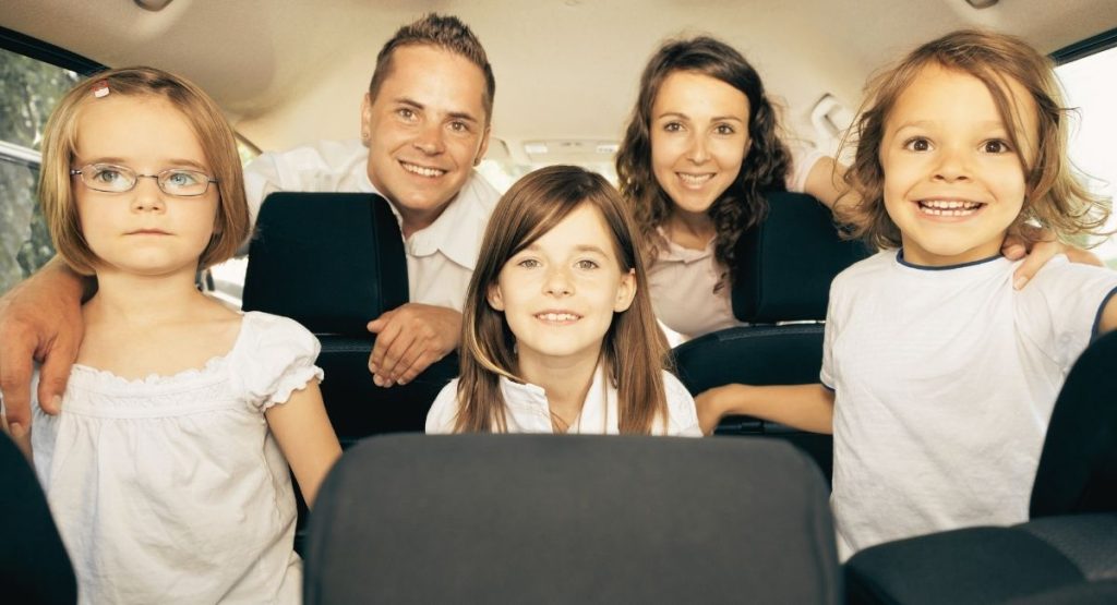 L'intérieur d'une voiture avec une famille de 5 personnes a l'intérieur