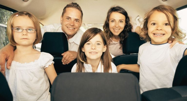 L'intérieur d'une voiture avec une famille de 5 personnes a l'intérieur