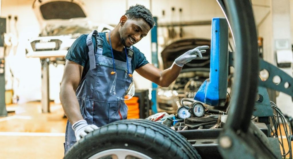 Mecanicien utilise un demonte-pneu numerique dans un atelier de garage