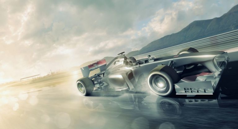 Voiture de course en pleine accélération sur un circuit humide, éclairée par les lumières du couchant