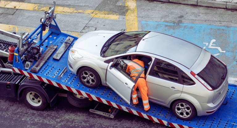Berline grise installee sur le plateau d un camion de transport de vehicules