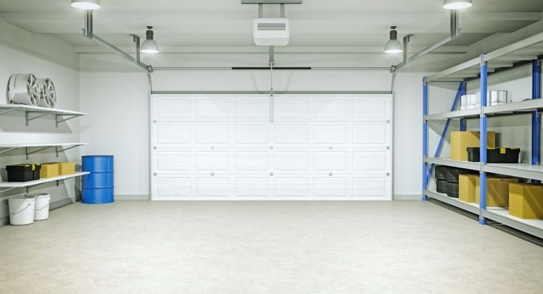Intérieur de garage vide avec porte sectionnelle blanche, sol clair et étagères de rangement